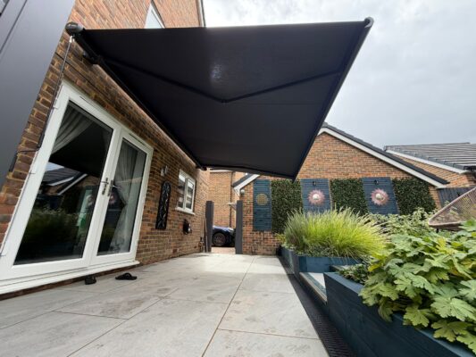 INT500 9 BEDWELL LANE RH10 3XP OPEN AWNING GREY FRAME SHADOW GREY FABRIC IN GARDEN VIEW 03.09.26