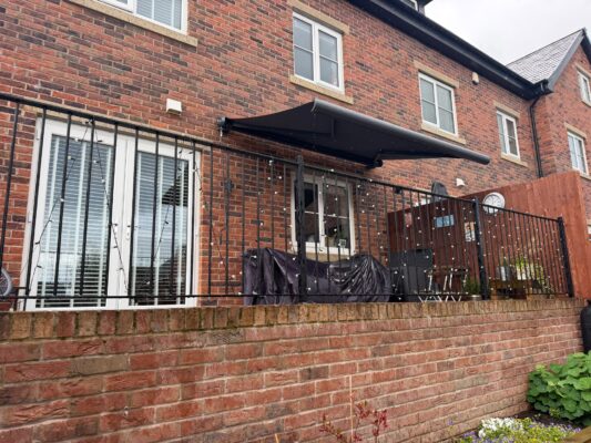 INT500 AWNING OPEN AWNING IN BACK GARDEN SHADOW GREY 3MX2.5M ON BRICKWALL M28 3TL 8.9.2026