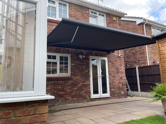 Grey frame awning canopy shading for patio garden by Intelroll limited UK Motorised LED LD7